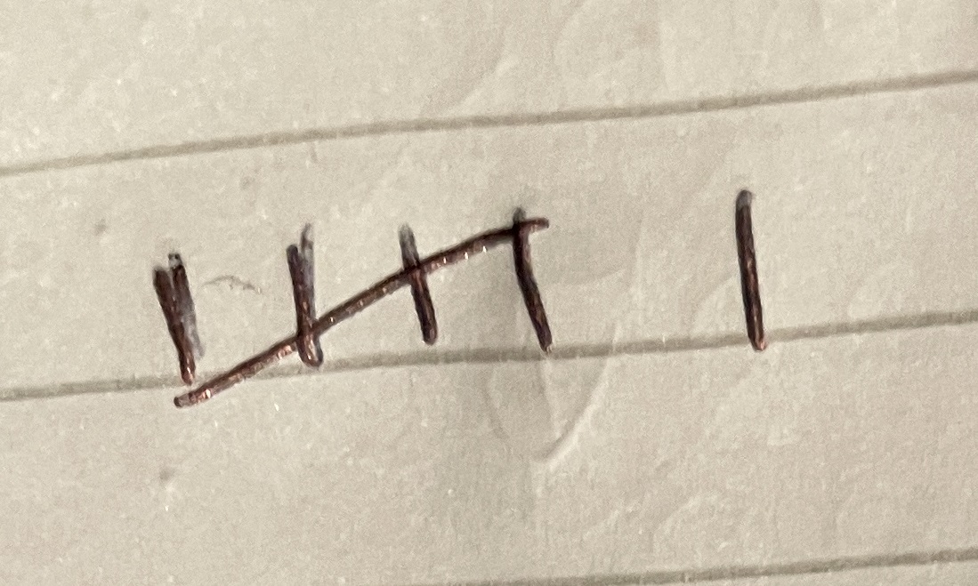 a close up of a wire on a wall with the word faith written on it with nails in the middle of the wire