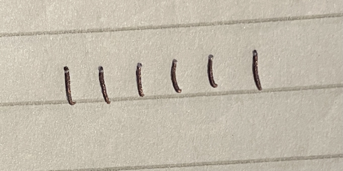 a close up of a building with nails sticking out of the side of the building and a stop sign on the side of the building